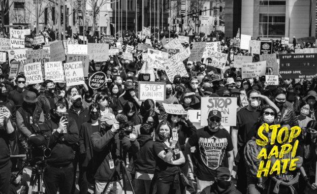 Cover of the Righting Wrongs Report, wiht a photo of a crowd at an anti-racism rally.